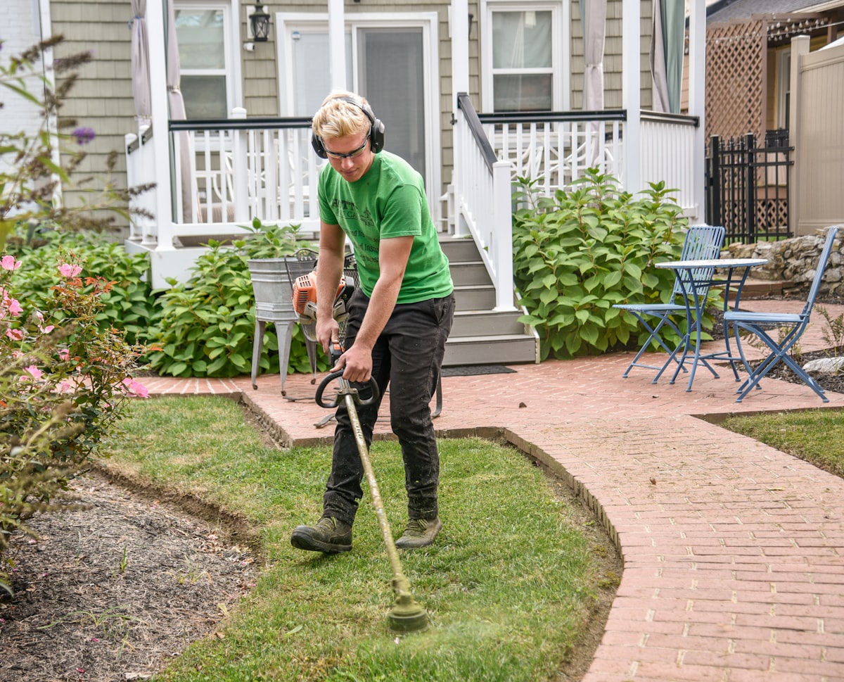 A West Meadow crew member edging a bed alongside a home